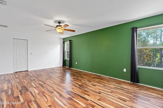 spare room featuring hardwood / wood-style flooring, ceiling fan, and a healthy amount of sunlight