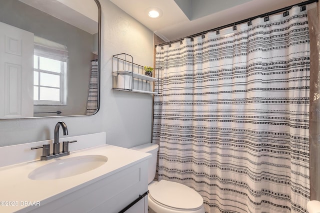 bathroom featuring walk in shower, vanity, and toilet