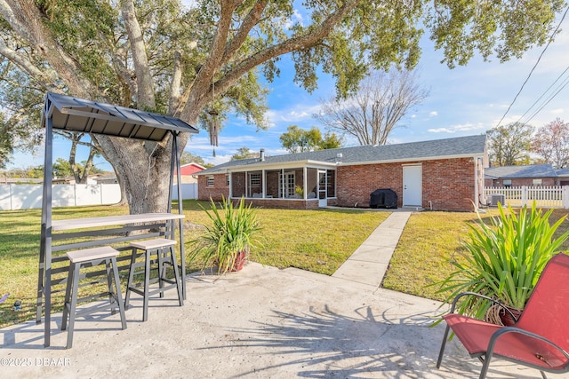 rear view of house with a patio area and a lawn