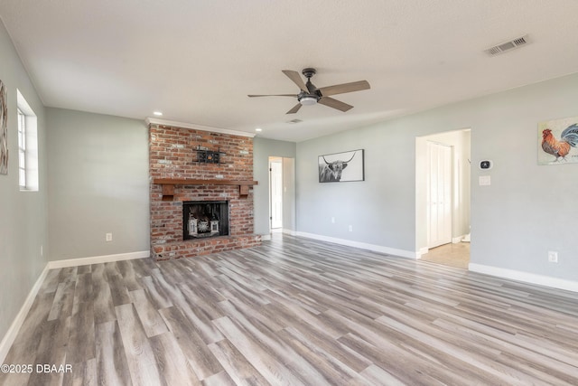 unfurnished living room with a fireplace, ceiling fan, and light wood-type flooring