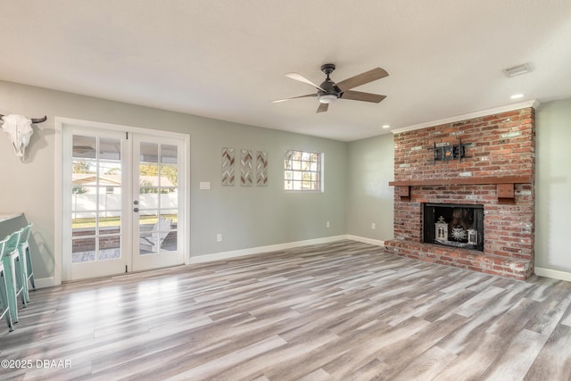 unfurnished living room with ceiling fan, light wood-type flooring, a textured ceiling, and a fireplace