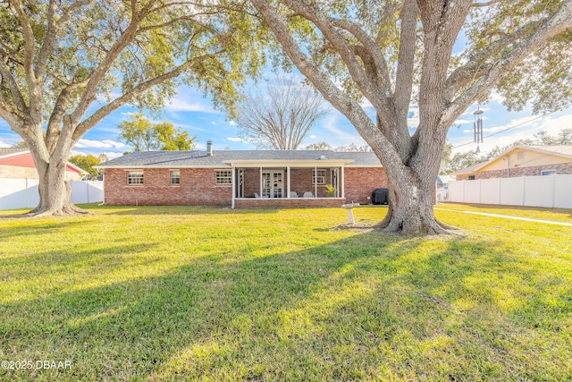 rear view of property with a yard