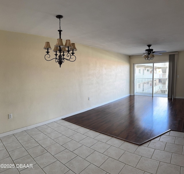 spare room featuring ceiling fan with notable chandelier and light wood-type flooring