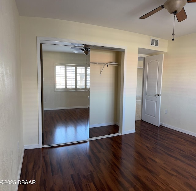 unfurnished bedroom with dark hardwood / wood-style floors, ceiling fan, and a closet