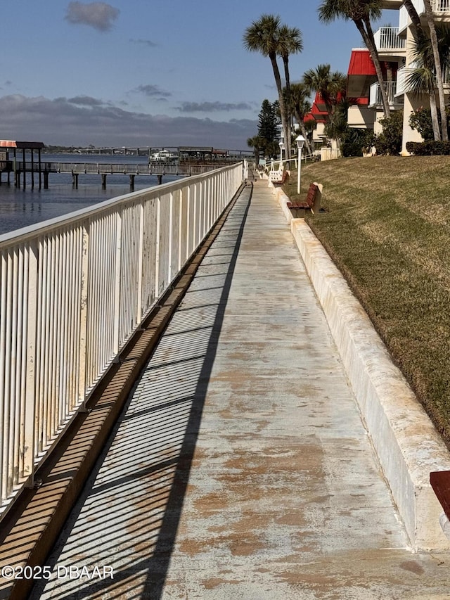 view of dock featuring a water view and a yard