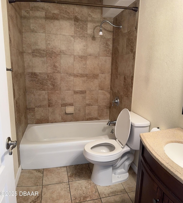 full bathroom featuring tile patterned flooring, vanity, tiled shower / bath, and toilet