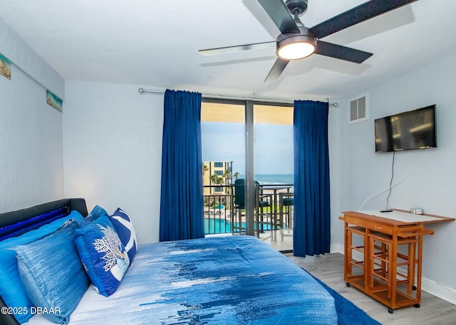 bedroom with expansive windows, ceiling fan, access to outside, and light hardwood / wood-style floors