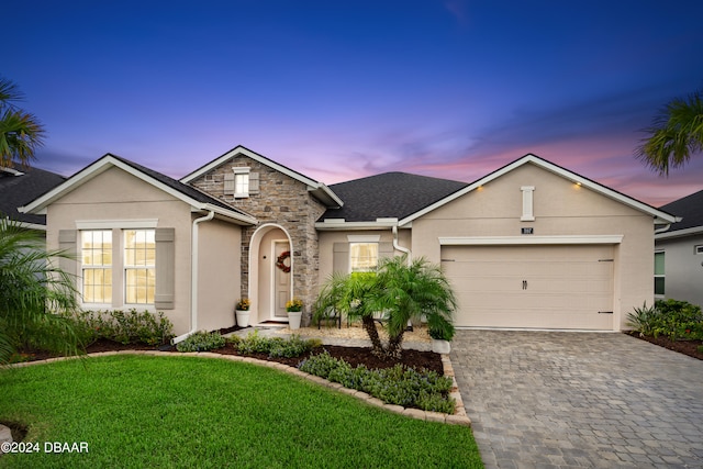 view of front of house with a garage and a lawn