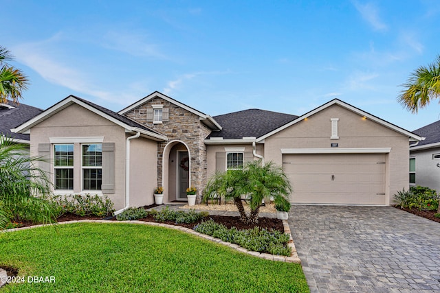 single story home featuring a front lawn and a garage