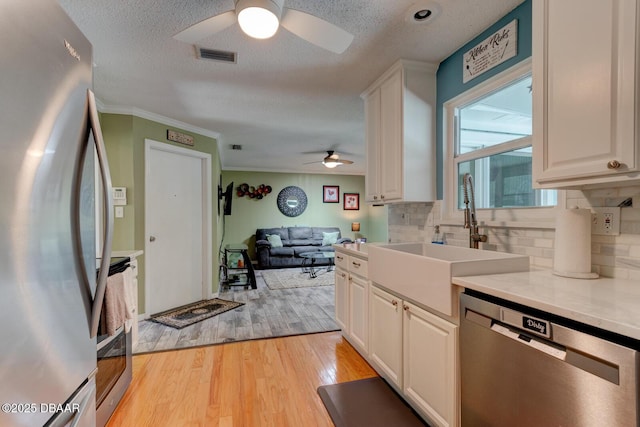 948 Northbrook Dr, Ormond Beach, FL 32174 - kitchen with appliances with stainless steel finishes, a ceiling fan, decorative backsplash, open floor plan, and light countertops