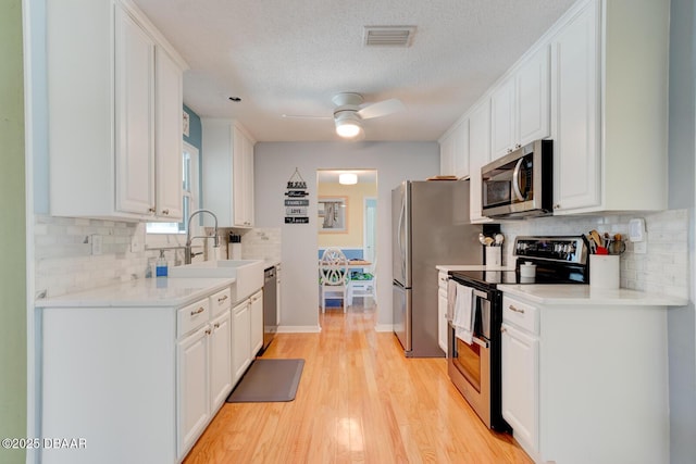 948 Northbrook Dr, Ormond Beach, FL 32174 - kitchen featuring stainless steel appliances, white cabinets, and a textured ceiling