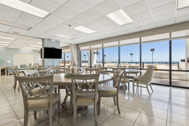 3003 S Atlantic Ave Unit 16B3, Daytona Beach Shores, FL 32118 - dining space with light tile patterned floors, a drop ceiling, and floor to ceiling windows