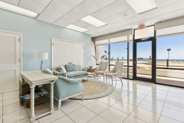 3003 S Atlantic Ave Unit 16B3, Daytona Beach Shores, FL 32118 - living room featuring tile patterned floors, a water view, a drop ceiling, and expansive windows