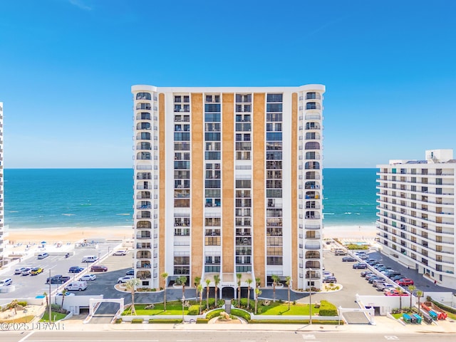view of apartment building / complex featuring view of water and beach