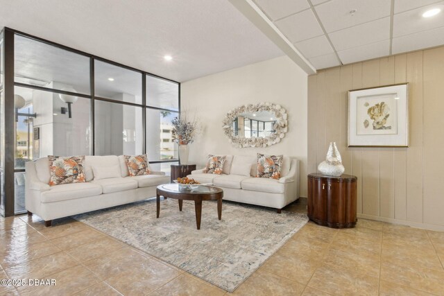3003 S Atlantic Ave Unit 16B3, Daytona Beach Shores, FL 32118 - tiled living area featuring healthy amount of natural light, expansive windows, wood walls, recessed lighting, and baseboards