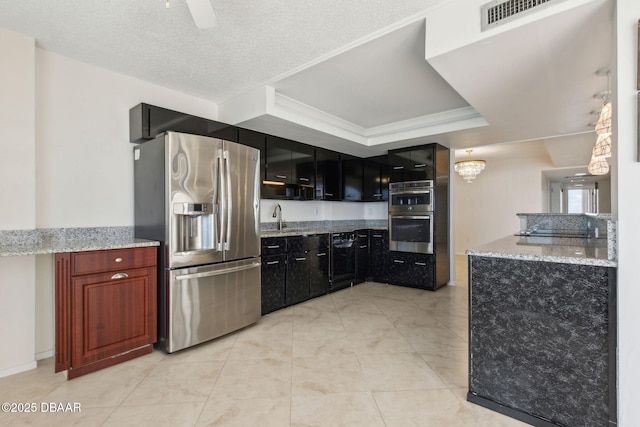 3003 S Atlantic Ave Unit 16B3, Daytona Beach Shores, FL 32118 - kitchen with stainless steel appliances, a tray ceiling, dark cabinetry, light stone countertops, and crown molding
