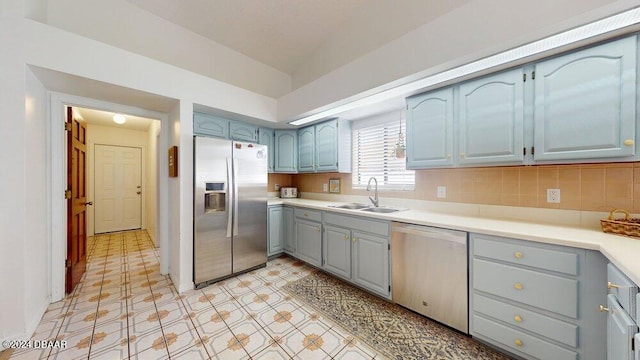 kitchen featuring backsplash, appliances with stainless steel finishes, and sink