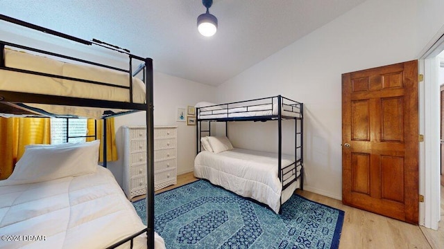 bedroom featuring vaulted ceiling and light hardwood / wood-style flooring