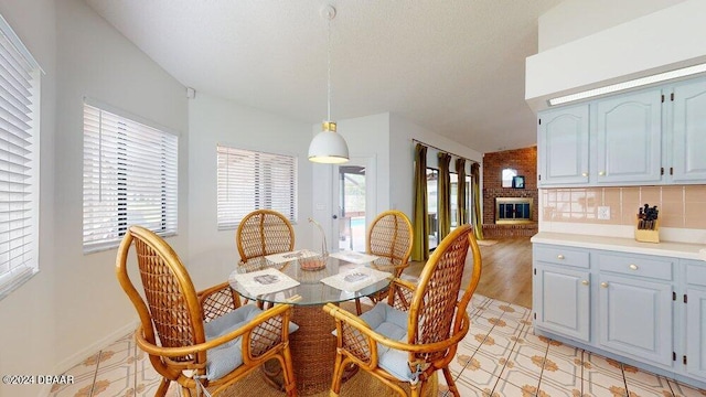 dining area with light hardwood / wood-style flooring and a brick fireplace