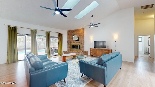 living room featuring a fireplace, light hardwood / wood-style floors, and high vaulted ceiling