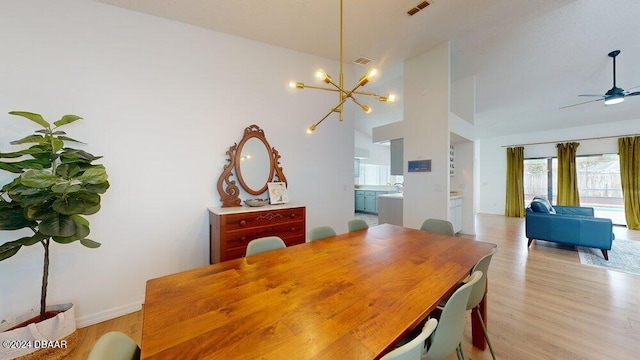 dining room with light wood-type flooring and ceiling fan with notable chandelier