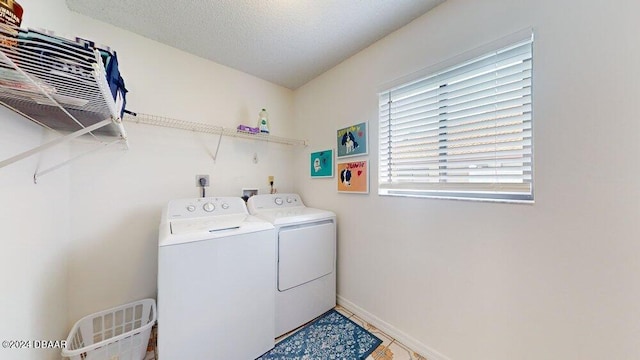 clothes washing area featuring washer and dryer and a textured ceiling