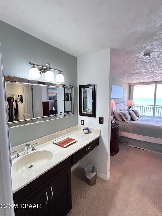 bathroom with ensuite bathroom, vanity, and baseboards