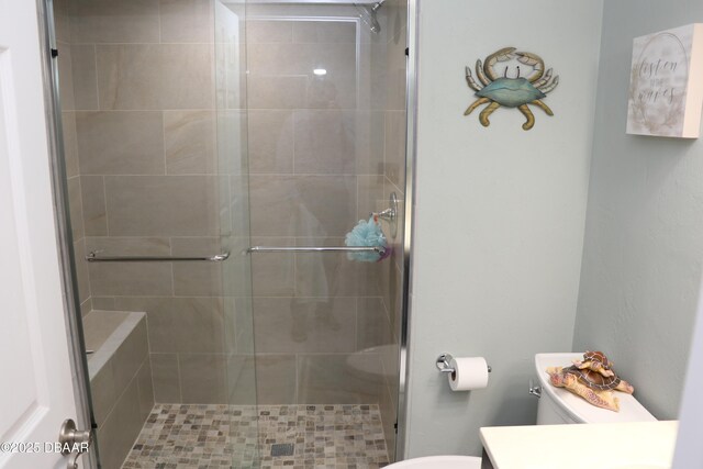 bathroom with vanity, a shower stall, and toilet