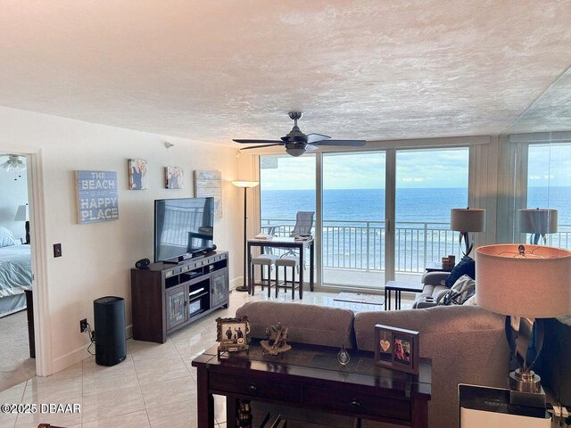 tiled living room with floor to ceiling windows, a textured ceiling, and ceiling fan