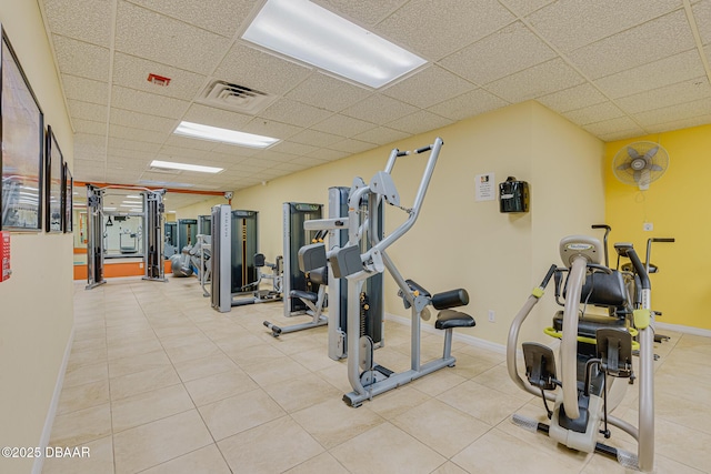 workout area featuring baseboards, visible vents, and a drop ceiling