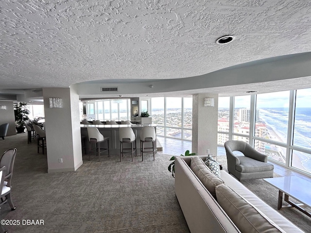 unfurnished living room with carpet floors, visible vents, and a textured ceiling