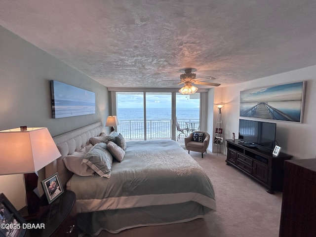 carpeted bedroom featuring access to outside, floor to ceiling windows, and ceiling fan