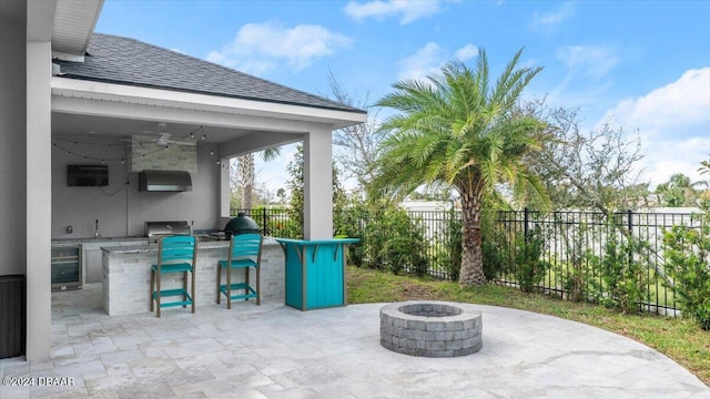 view of patio with an outdoor bar, an outdoor fire pit, ceiling fan, and wine cooler