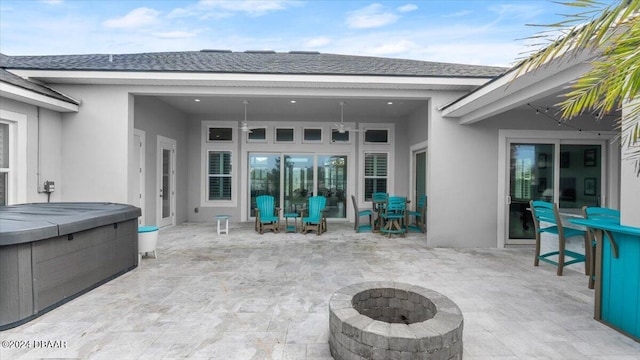 view of patio / terrace featuring a hot tub and an outdoor fire pit