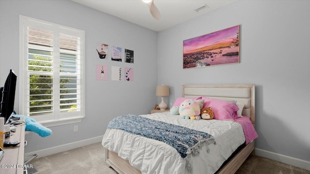 bedroom featuring ceiling fan, multiple windows, and carpet flooring