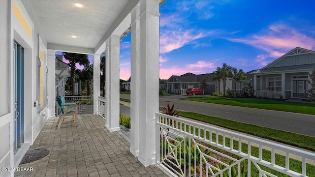 patio terrace at dusk featuring covered porch