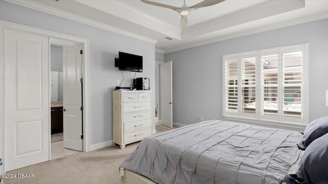 bedroom with light colored carpet, connected bathroom, ceiling fan, a raised ceiling, and crown molding