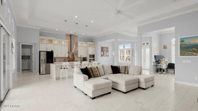 living room with ceiling fan and ornamental molding