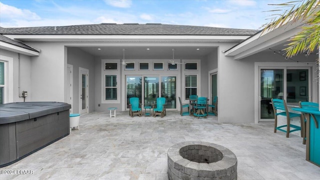 view of patio / terrace with a hot tub, a fire pit, and ceiling fan