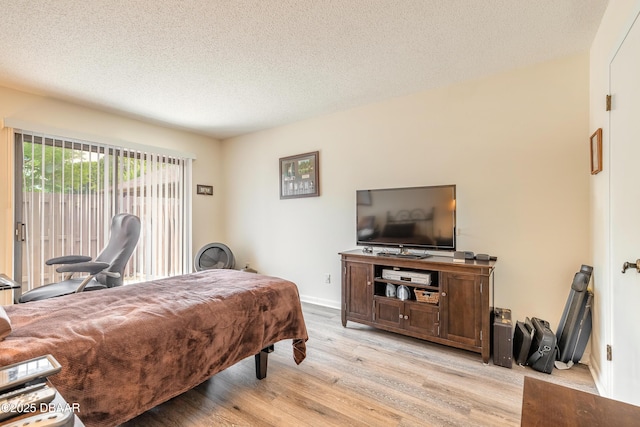 107 White Ibis Ct, Daytona Beach, FL 32119 - bedroom with light wood-type flooring, access to exterior, a textured ceiling, and baseboards