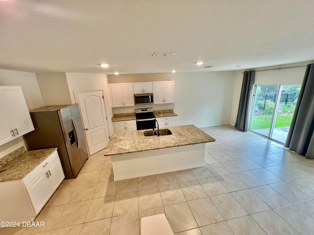 kitchen with stainless steel appliances, a center island with sink, light stone counters, white cabinets, and sink