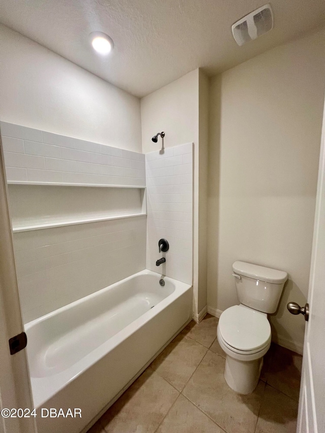 bathroom with toilet, bathing tub / shower combination, a textured ceiling, and tile patterned floors