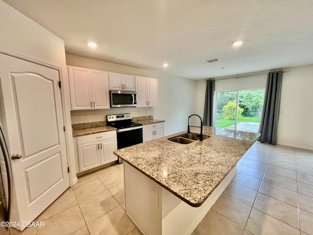 kitchen featuring white cabinetry, stainless steel appliances, a center island with sink, and sink