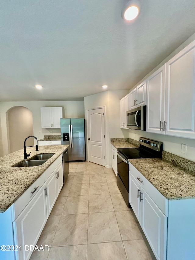 kitchen with an island with sink, white cabinetry, sink, and appliances with stainless steel finishes