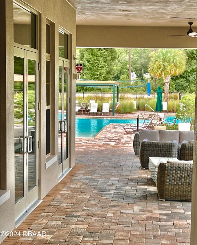 view of swimming pool with a patio area, french doors, and ceiling fan