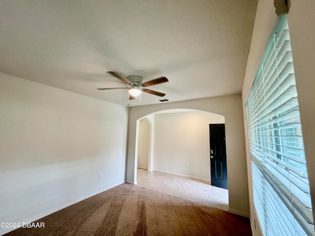 spare room featuring ceiling fan and light carpet