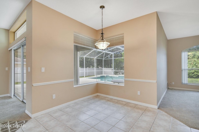 unfurnished dining area featuring light colored carpet and lofted ceiling