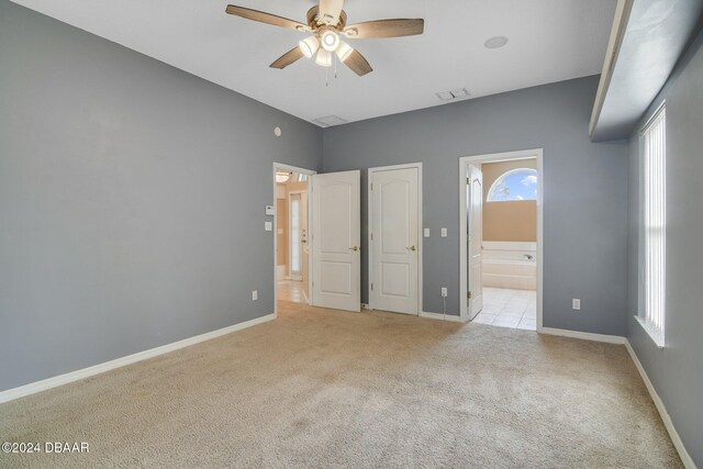 5976 Sawgrass Point Dr, Port Orange, FL 32128 - unfurnished bedroom featuring light carpet and ensuite bathroom