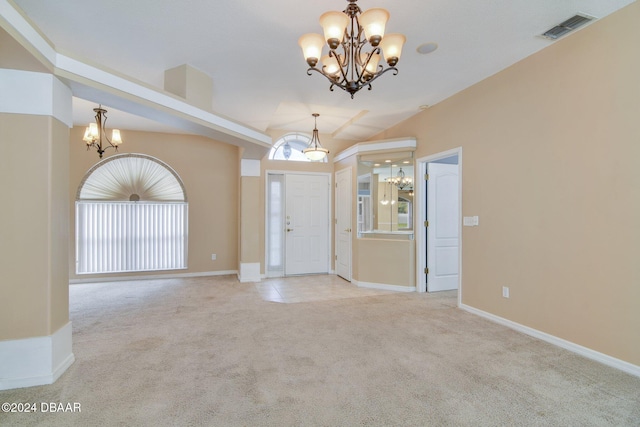 entrance foyer with light carpet and a chandelier