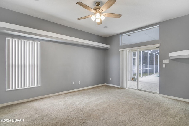 carpeted spare room with ceiling fan